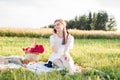 Field in daisies, a bouquet of flowers.French style romantic picnic setting. Woman in cotton dress.takes pictures Royalty Free Stock Photo