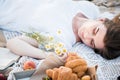 Field in daisies, a bouquet of flowers.Summer picnic by the sea. basket for a picnic with with buns, apples and juice Royalty Free Stock Photo