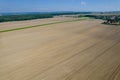 Field and dirt road near the village. Summer landscape with field, forest and picturesque sky. View from above. Royalty Free Stock Photo