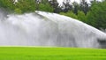 A field of a farmer is moistened with water by a large sprinkler