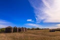 A field with a few old grain silos and a tractor Royalty Free Stock Photo