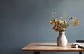 Field flowers in clay vase on wooden table against dark blue wall background. Interior design of modern living room with space for Royalty Free Stock Photo