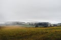 Meadow with fog over the mountains