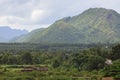 Field and forest against the big mountain and cloudys sky. Royalty Free Stock Photo