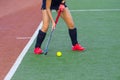 Field hockey player, in possesion of the ball, running over an astroturf pitch, looking for a team mate to pass to Royalty Free Stock Photo