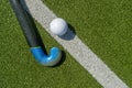 Field hockey stick and ball on the green field