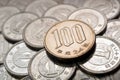 A field of Japanese coins in 1 yen, on it lies a coin of 100 yen. News about the economy, finances and interest rate of the Royalty Free Stock Photo