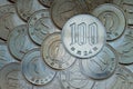 A field of Japanese coins in 1 yen, on it lies a coin of 100 yen. News about the economy, finances and interest rate of the Royalty Free Stock Photo