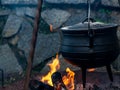 field kitchen with metal cauldron on fire