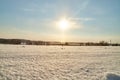 Field, meadow and grass with snow and cold sun on foggy cloudy sky. Beautiful winter landscape. Winter morning, day or Royalty Free Stock Photo