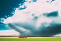 Field Or Meadow Landscape With Green Grass Under Scenic Spring Blue Dramatic Sky With White Fluffy Clouds. Rain Clouds Royalty Free Stock Photo