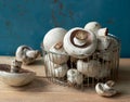 Field mushrooms in the steel kitchen basket on rustic wooden table Royalty Free Stock Photo