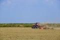 Tractor with a grader aligns the soil on the field. The tractor raised dust.