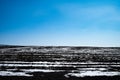 A field partially covered with snow on a hill