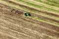 An aerial view of a tractor plowing in a field.