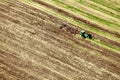 An aerial view of a tractor plowing in a field.