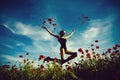 Field of poppy seed with woman jumping