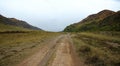 A field road ascending into a hollow between the mountains Royalty Free Stock Photo