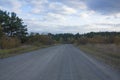 The field road leads to the autumn forest. Autumn landscape on a cloudy day Royalty Free Stock Photo