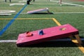 Field set up with cornhole boards and other backyard games