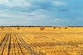 Field with straw bales after harvest with cloudy sky in sunset t Royalty Free Stock Photo