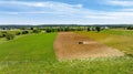 Field with a tractor in the foreground and a blue sky in the background Royalty Free Stock Photo