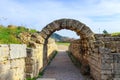 The field where the original Olympics were held viewed through the ruins of the arch through which the Greek atheletes ran in Olym Royalty Free Stock Photo