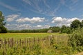 Field with wooden fence. Blue sky with delicate white clouds. Polish village view. Royalty Free Stock Photo