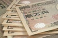 A field of 10000 yen Japanese notes. Background or wallpaper with reduced contrast and color saturation. A bundle of bills.