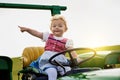 Those fields need plowing. Portrait of an adorable little girl riding a tractor on a farm. Royalty Free Stock Photo