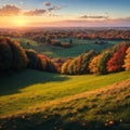 Fields and trees in a green hilly grassy landscape under a blue sky at sunrise in autumn, Voeren, Limburg, Belgium, Royalty Free Stock Photo