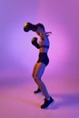 Fierce and confident, determined boxer girl, professional sportsman posing against gradient studio background in violet