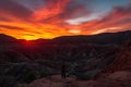 fiery canyon sunset with silhouetted figure on the ridge, viewing the scene