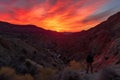 fiery canyon sunset with silhouetted figure on the ridge, viewing the scene