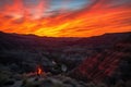 fiery canyon sunset with silhouetted figure on the ridge, viewing the scene