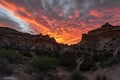 fiery canyon sunset with silhouetted rock formations and clouds