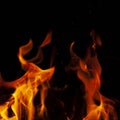 Fiery flame with sparks on a black background. Texture element for barbecue or cooking