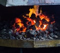 Fiery furnace with coal and hot metal parts for further processing, old forge, cooker Royalty Free Stock Photo