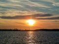 Fiery glow sunset over the Baltic sea water. Different colours of clouds and the silhouette of shipyard in Gdynia City, Poland Royalty Free Stock Photo