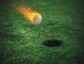 Fiery golf ball near the hole in a grass field Royalty Free Stock Photo