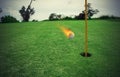 Fiery golf ball near the hole in a grass field Royalty Free Stock Photo