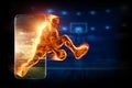 The fiery image of a basketball player cuts out of his smartphone. Creative collage, sports app. Concept for online store, online