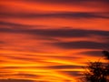 Fiery sunset during fall season. Colored clouds creating clouds and abstract shapes in sky Royalty Free Stock Photo