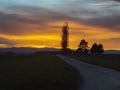 Fiery sunset over a rural town with narrow asphalt road Royalty Free Stock Photo