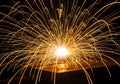 Fiery welding sparks exploding outward against a dark background Royalty Free Stock Photo