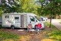 Enjoy a nice autumn sun next to the camper at a campsite.