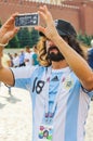 The 2018 FIFA World Cup. Argentine fan in striped white-blue t-shirts in colors of the flag of Argentina takes pictures on a smart Royalty Free Stock Photo