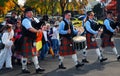 A bagpipe and drum band leads a group of costumed children in a Halloween parade