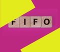 FIFO First in, first out word on wooden cubes on blue. Accounting Concept Royalty Free Stock Photo