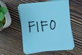 FIFO write on sticky notes isolated on Wooden Table